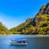 A tour boat cruising past dramatic limestone cliffs and mangrove forests in Langkawi, Malaysia